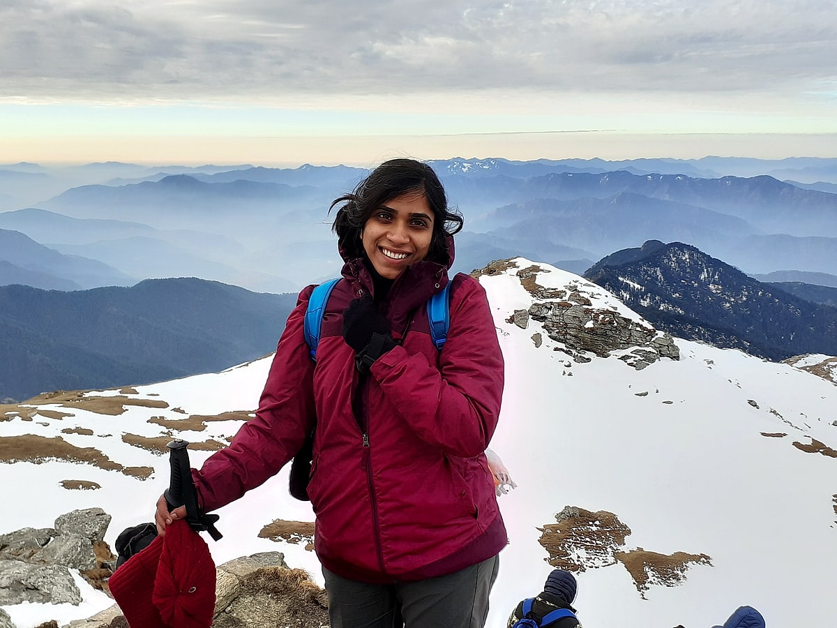 On the snowy Kedarkantha summit ridge, blue hills fading behind