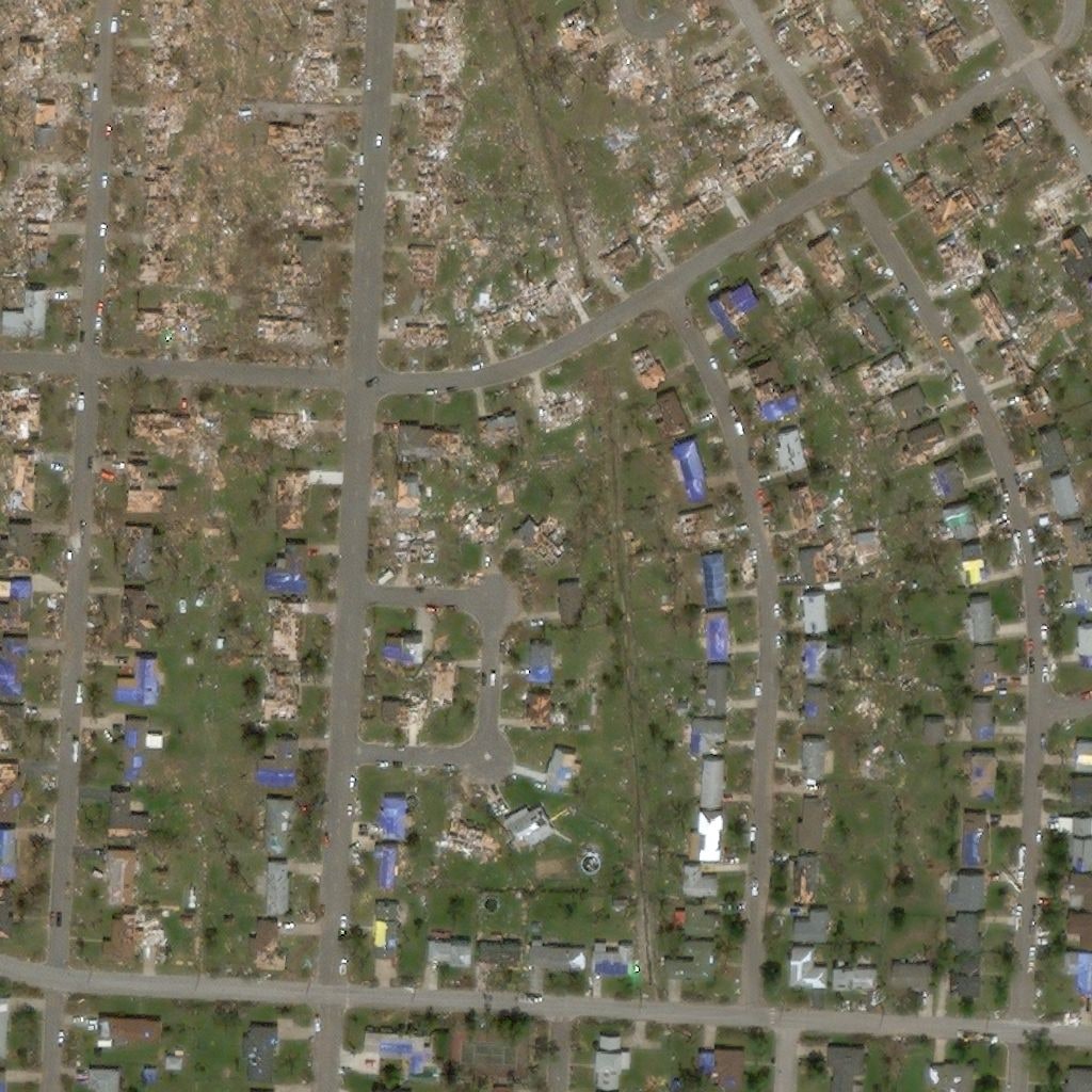 The same neighbourhood after the hurricane, many roofs gone
